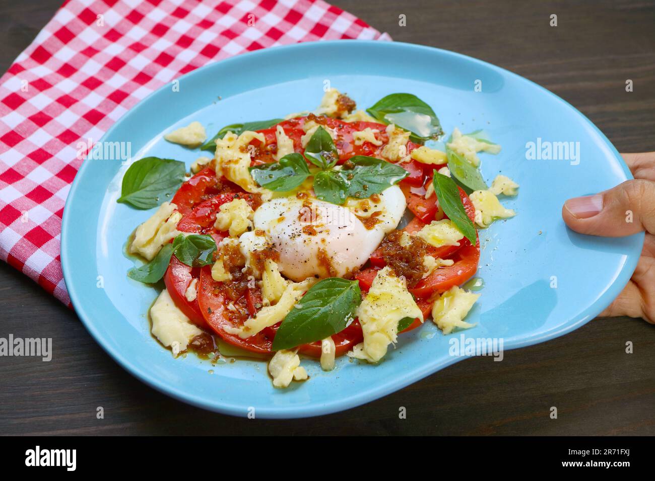 Appetitosa insalata caprese fatta in casa con un uovo in camicia per una sana colazione Foto Stock
