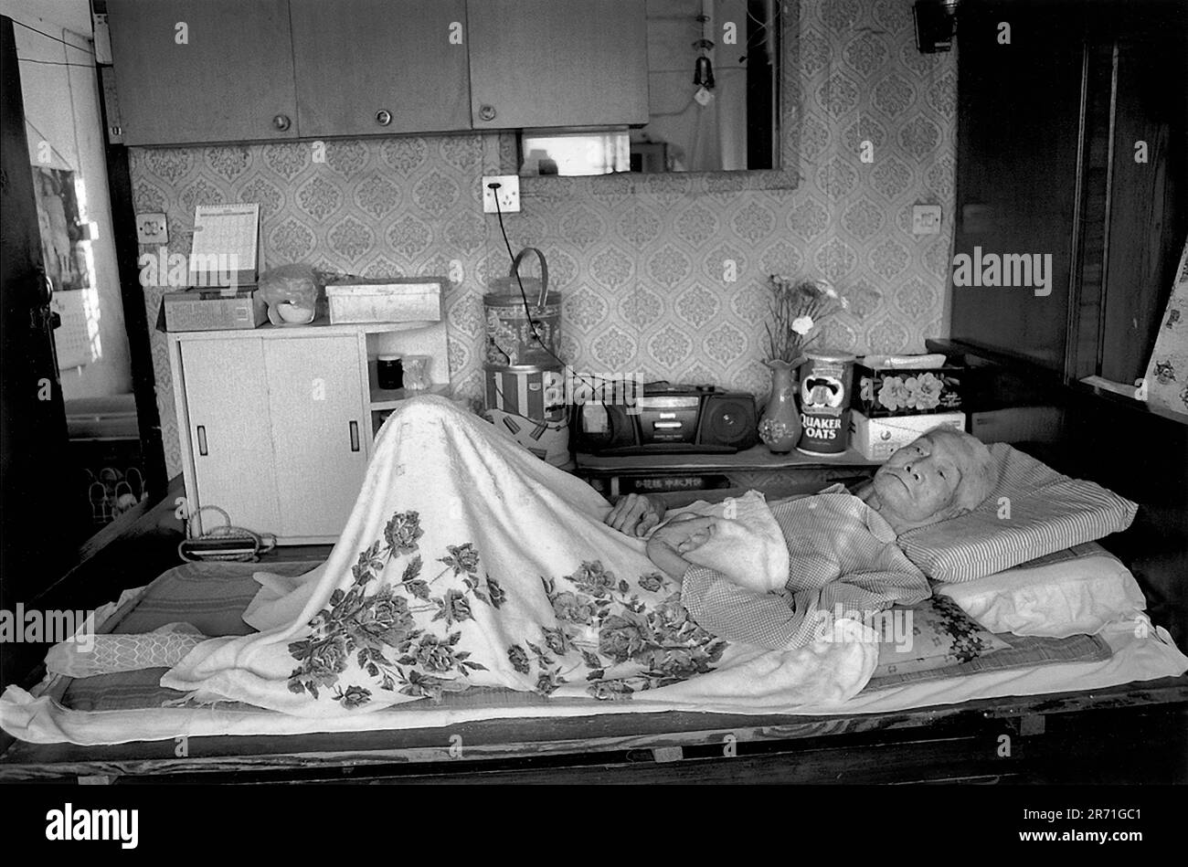 Shanghai Cina 2000. Il signor Xu Hou Shen di 89 anni, che ha lavorato a Hamilton House dall'età di diciassette anni, giace sul suo letto di morte nel suo appartamento di due stanze in cima all'edificio. Egli ricorda Hamilton House 'ai bei vecchi tempi' quando solo ricchi cinesi e stranieri potevano vivere lì. Fu Zhou Building, ex Hamilton House, dove è stato concepito l'autore. Edificio di Fuzhou 170 Jiangxi Middle Road, distretto di Huangpu 2000s HOMER SYKES Foto Stock