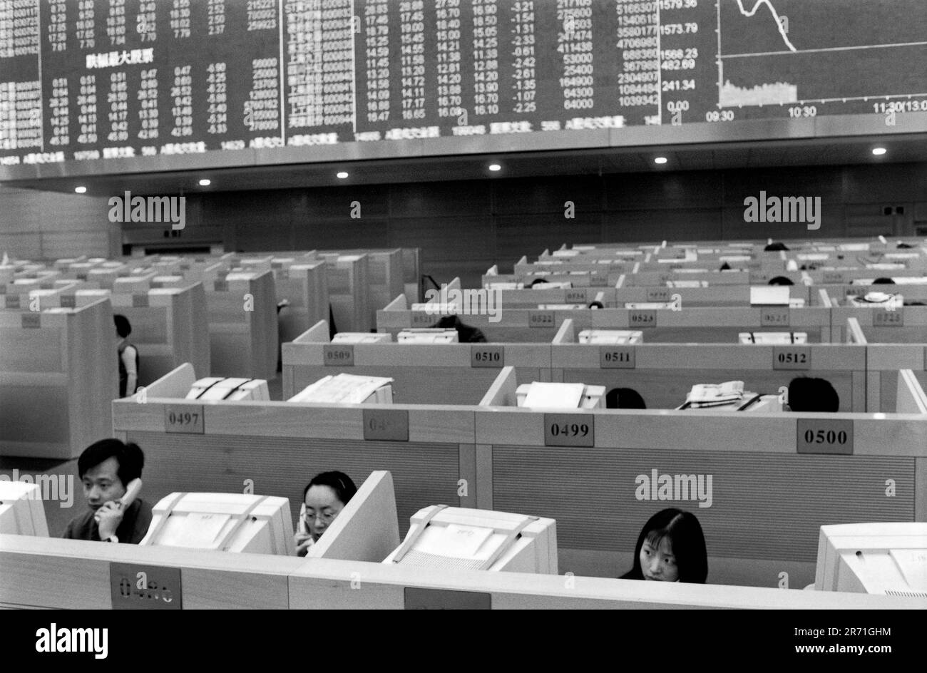 Shanghai Cina 2000. "Giubbotti rossi" sul piano commerciale dell'edificio della Borsa di Shanghai a Pudong, che ha aperto alla fine del 1997. La più grande della Cina continentale, la borsa è stata stabilita soltanto a Shanghai in 1990 ma ora ha più di 600 società quotate ed il mercato è il numero di valore due nella regione Asia-Pacifico. È la politica del governo incoraggiare le persone a essere coinvolte nel mercato azionario poiché molte società quotate sono di proprietà statale, o ex di proprietà statale, e hanno un grave bisogno di capitale. 2000s OMERO SYKES Foto Stock