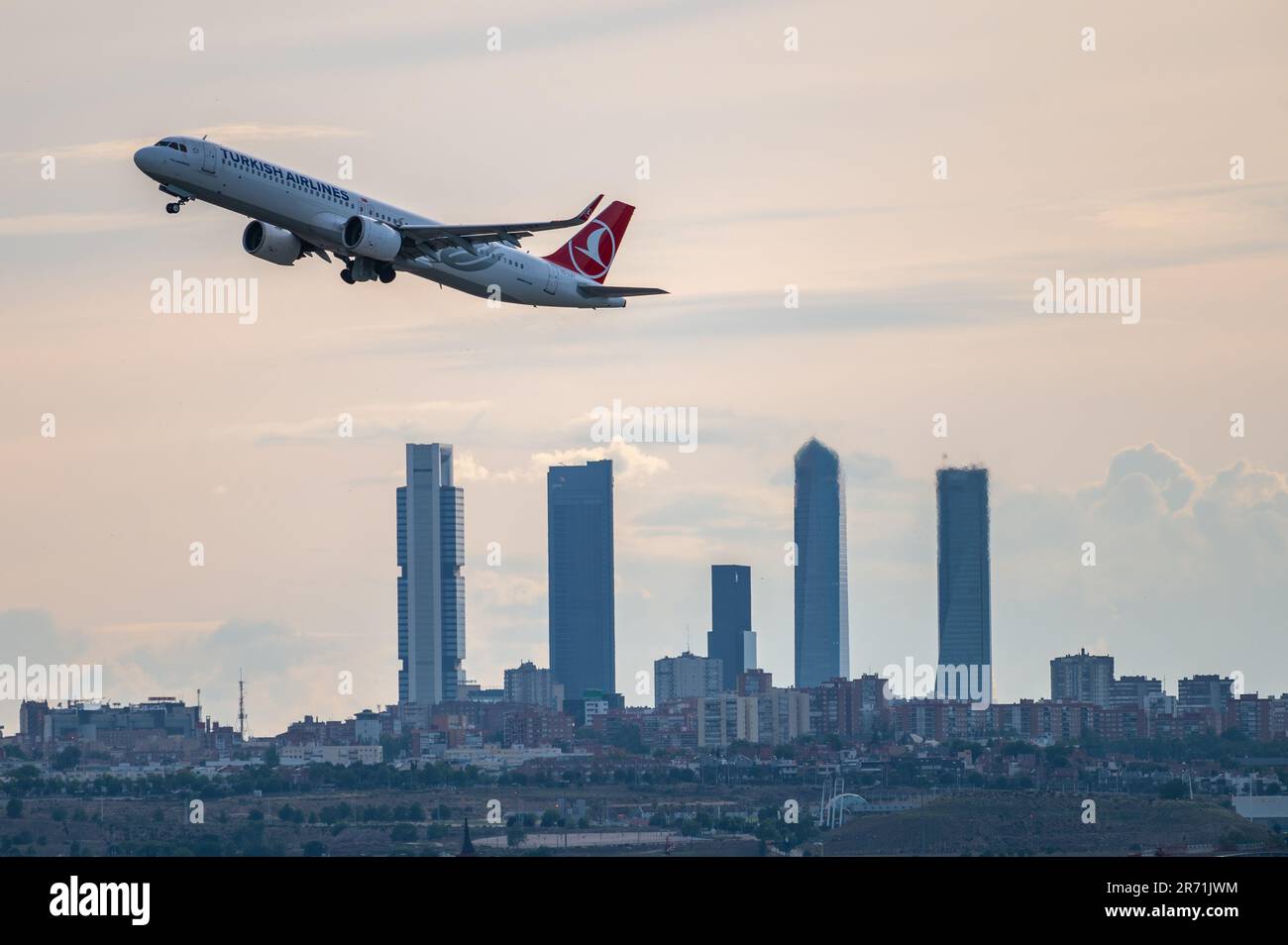 Un Airbus A321 di volo commerciale Turkish Airlines vola sopra i grattacieli dello skyline di Madrid, conosciuta come la "zona commerciale delle quattro torri", dopo la de Foto Stock