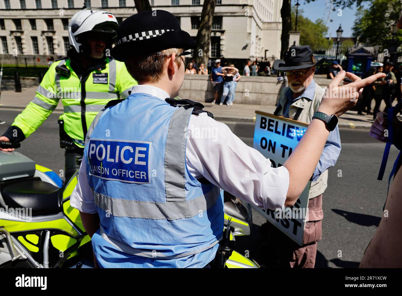 Inghilterra, Londra, Westminster, manifestanti che marciano al di fuori di Downing Street, ufficiali di collegamento della polizia che si impegnano con un manifestante religioso. Foto Stock
