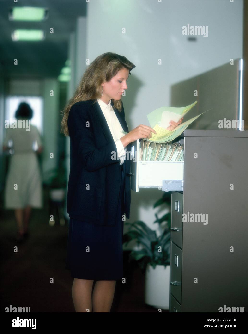 Uomini d'affari. Giovane donna. Executive. In piedi al file cabinet. Foto Stock