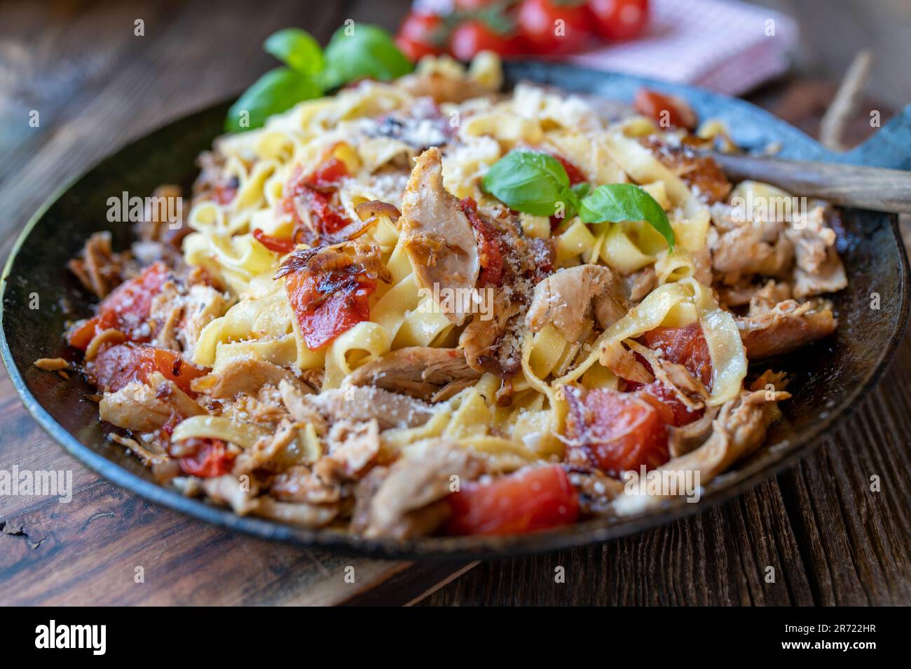 Pasta con carne di pollo, pomodori, cipolle rosse, erbe aromatiche e parmigiano Foto Stock
