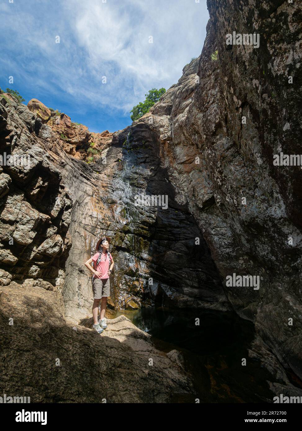 Oklahoma, 6 2023 MAGGIO - veduta soleggiato di una donna che si trova nella cascata di Post Oak delle montagne di Wichita Foto Stock
