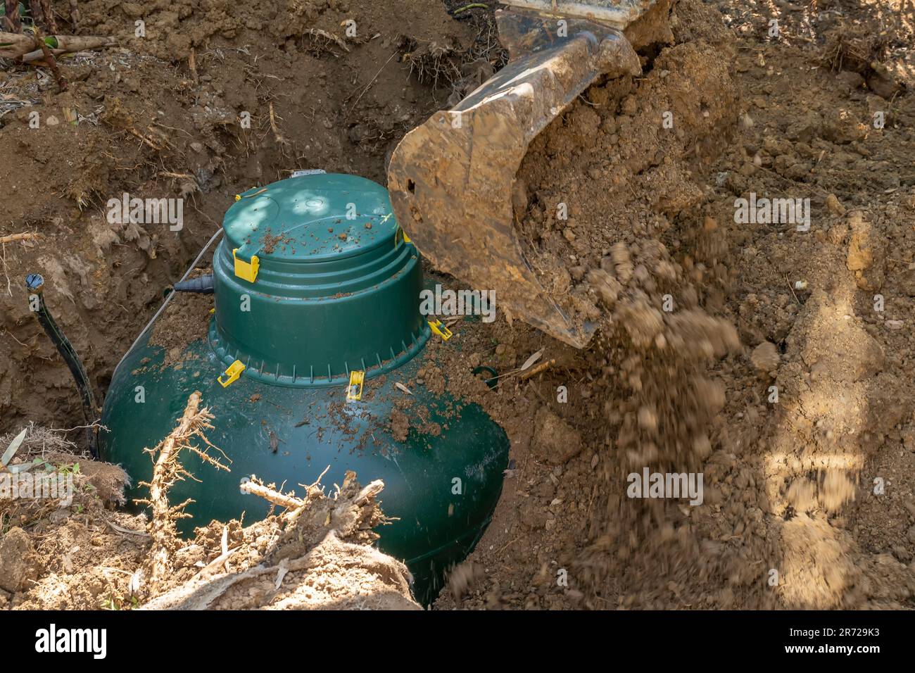 Un serbatoio di gas GPL è interrato con l'aiuto di un escavatore Foto Stock