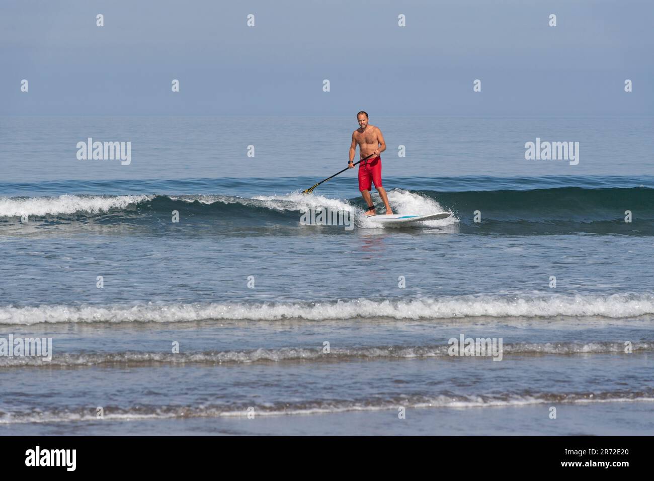 uomo su una tavola da pagaia nel surf Foto Stock