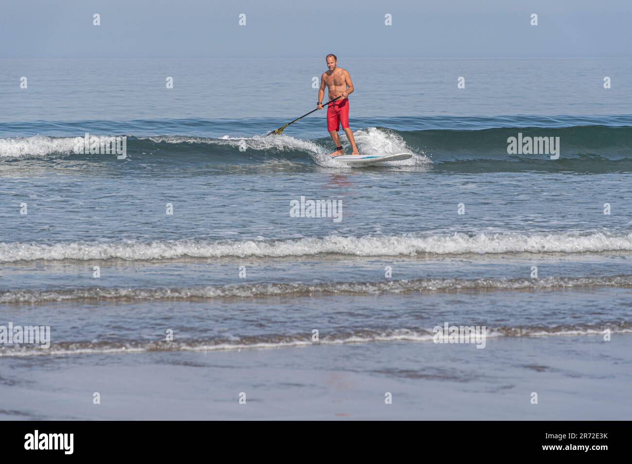 uomo su una tavola da pagaia nel surf Foto Stock