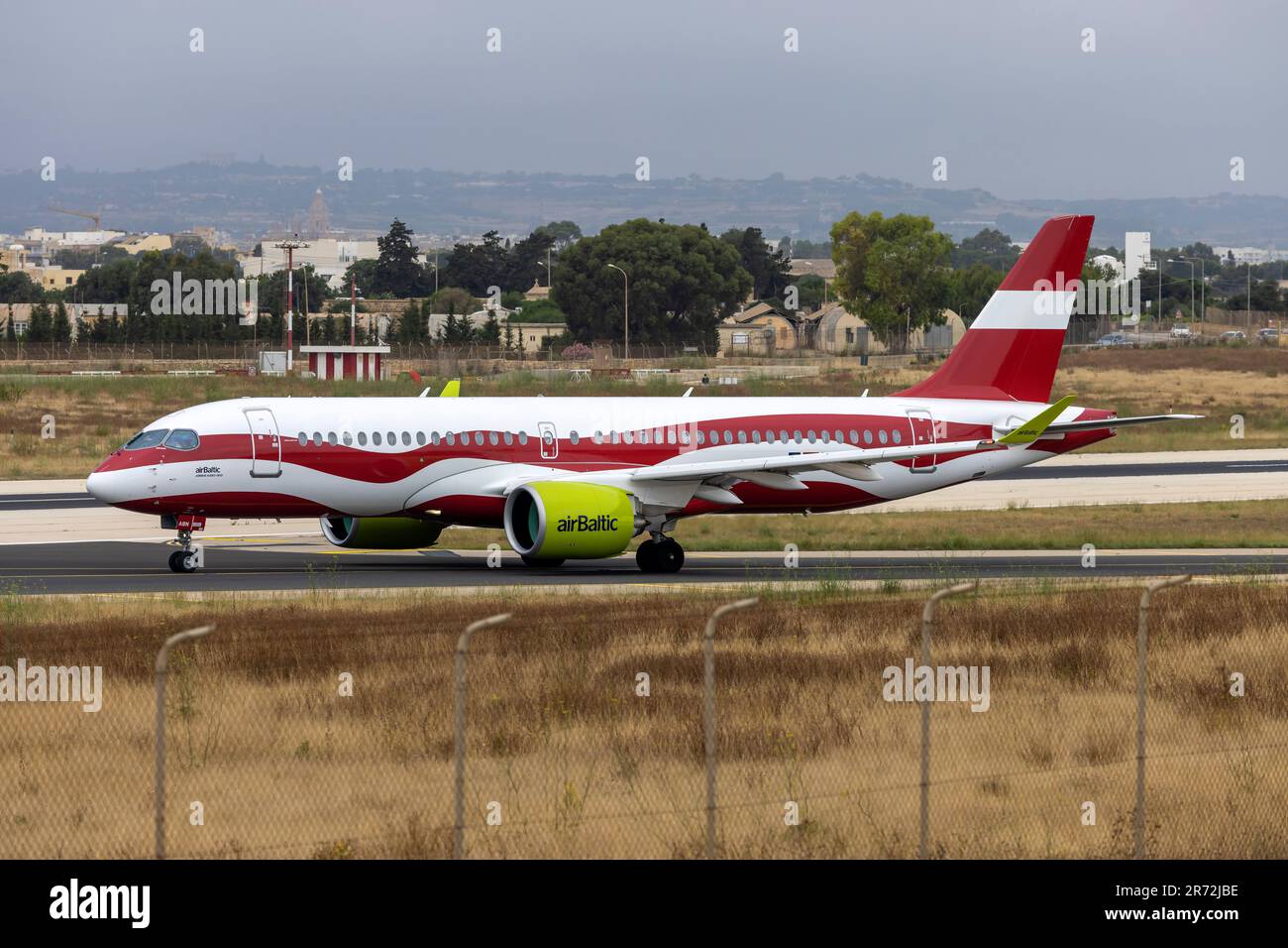 Air Baltic Airbus A220-300 (REG: YL-ABN) dipinta con i colori della bandiera lettone che entrano nella pista 31 per il decollo. Foto Stock