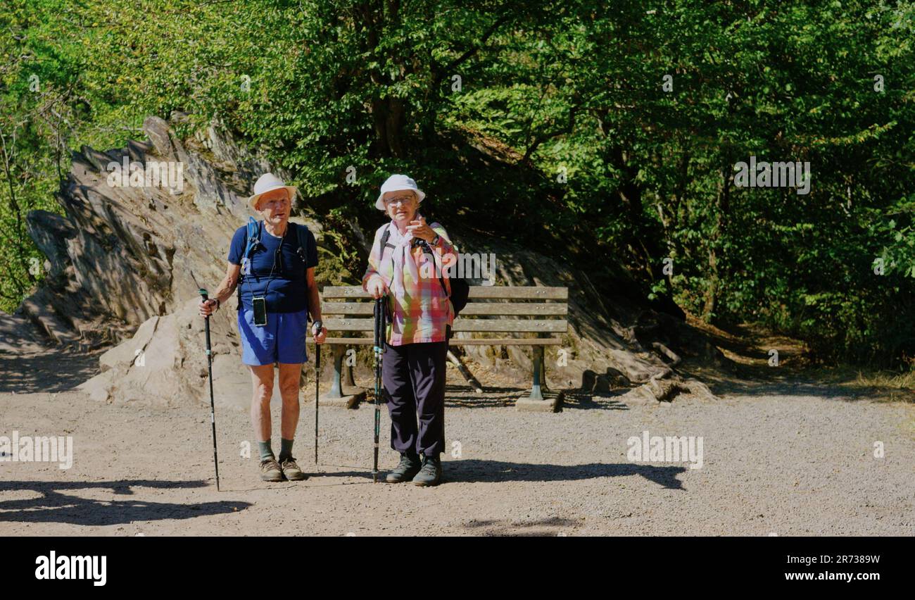 Più bello anziani Coppia escursionistica nel mondo, mostra esercizio è per tutti. Bastoni da nordic walking, zaino e un cappello da sole. Foto Stock