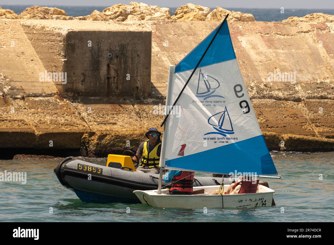 L'istruttore in un gommone spiega le basi della navigazione agli studenti in una barca a vela fotografata nell'antico porto di Jaffa Foto Stock