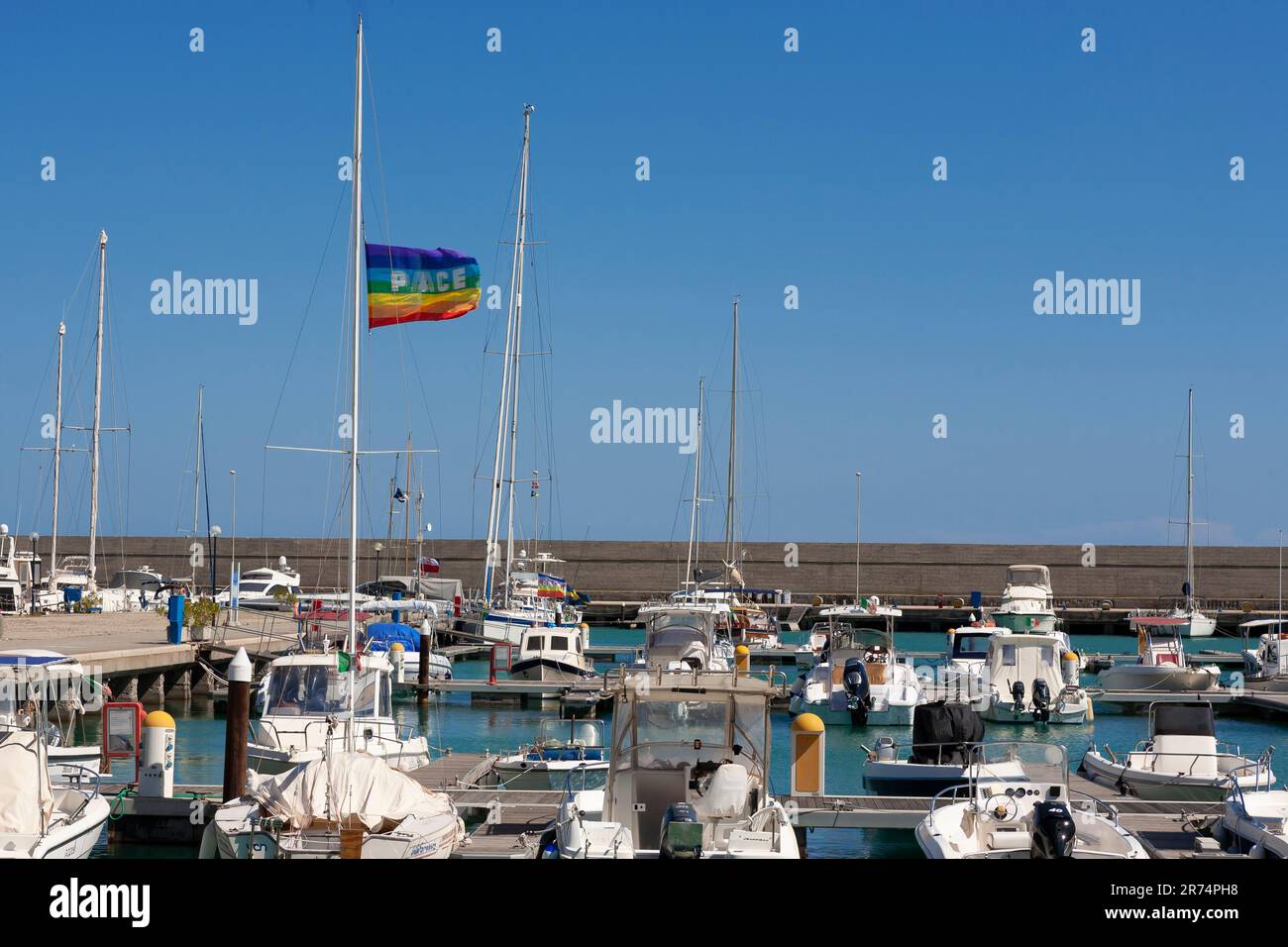 Bandiera della pace che vola su uno yacht, Rocella Ionica Marina, Calabria, Italia Foto Stock