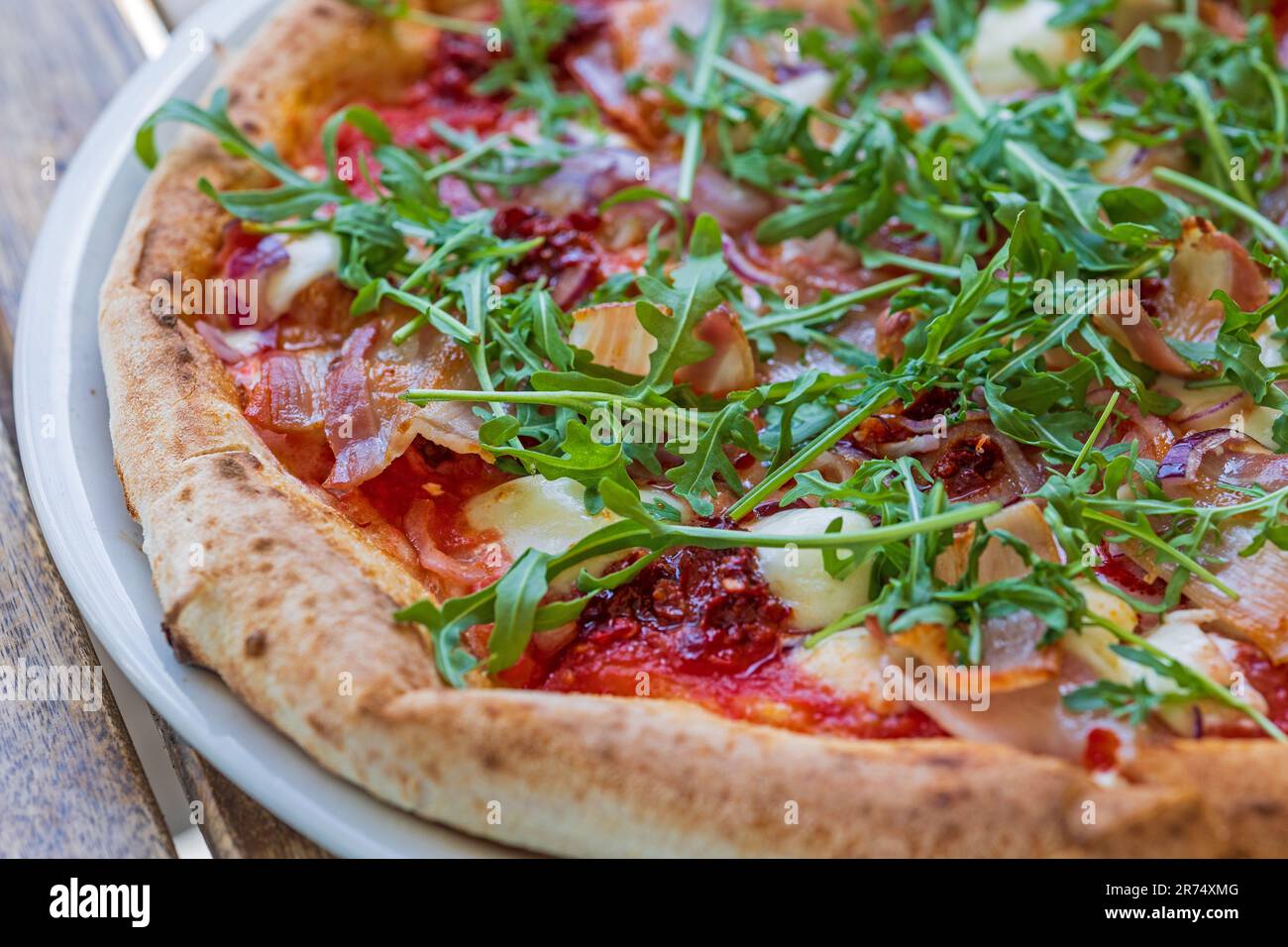 gustosa pizza appena sfornata su un tavolo di legno Foto Stock