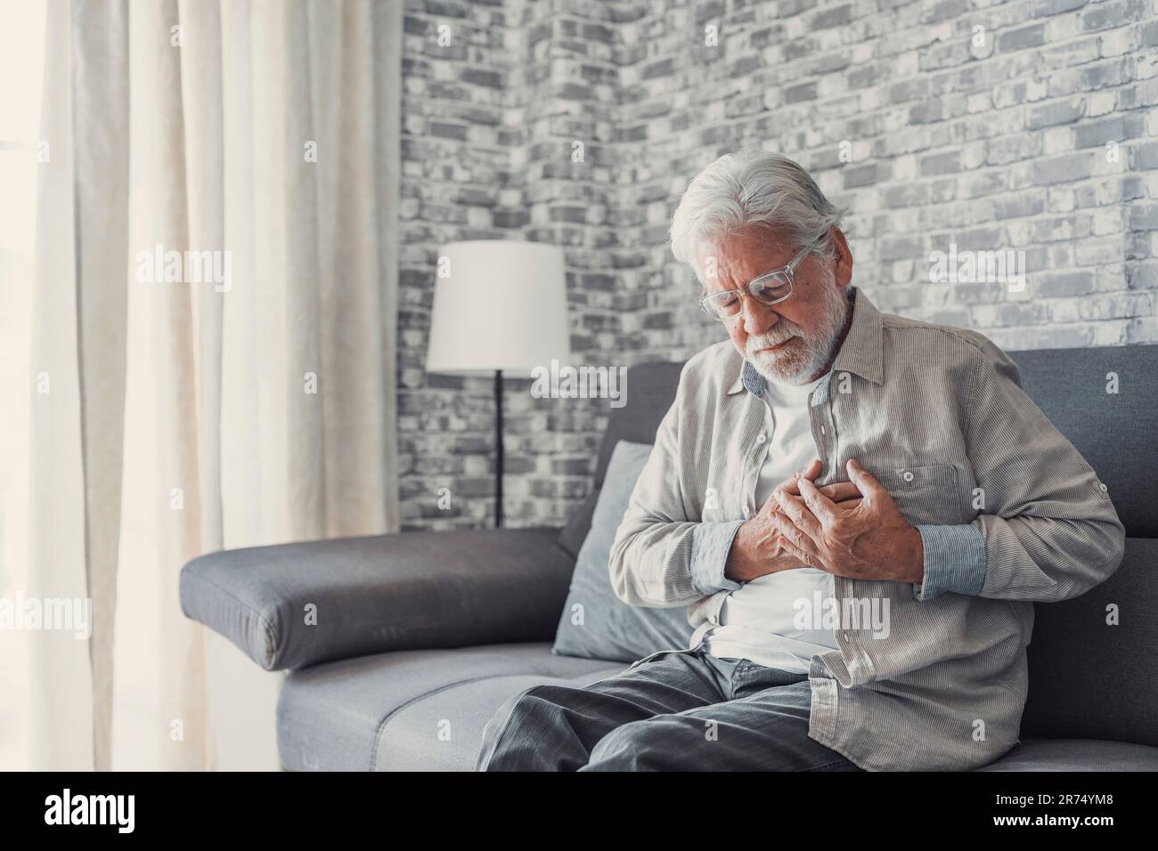 L'anziano preoccupato sentirsi male, il vecchio nonno di mezza età sconvolto toccare il petto sentire dolore improvviso bruciore di stomaco avendo attacco di cuore sedersi sul divano a casa Foto Stock L'anziano preoccupato sentirsi male, il vecchio nonno di mezza età sconvolto toccare il petto sentire dolore improvviso bruciore di stomaco avendo attacco di cuore sedersi sul divano a casa Foto Stock