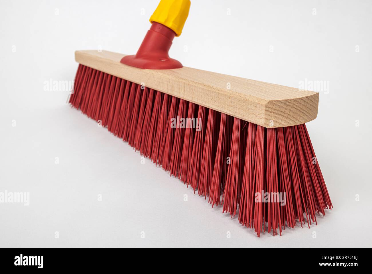 Scopa da strada con setole rosse, senza manico in legno, particolare, fondo bianco, Foto Stock