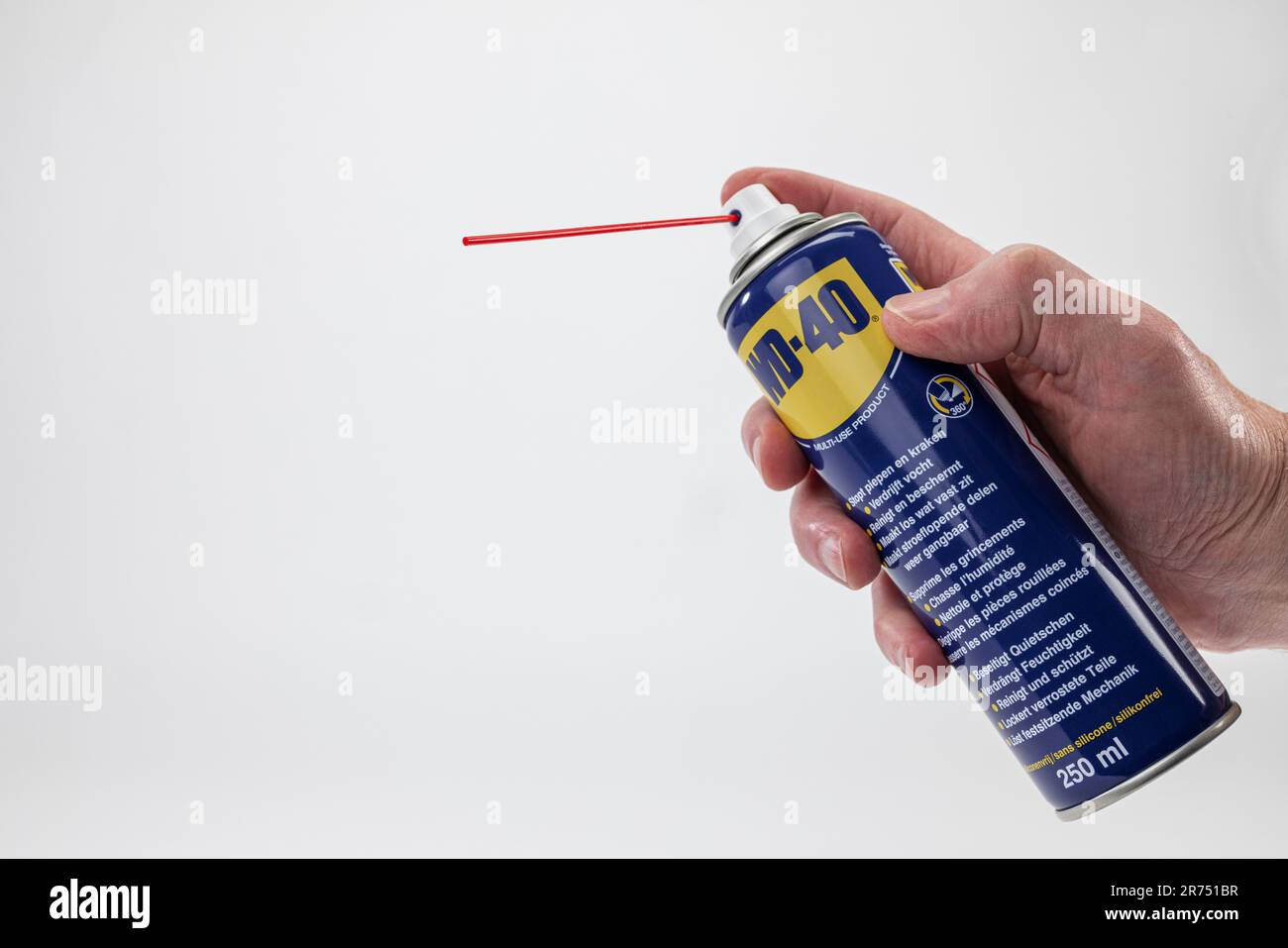 Man mano che regge WD-40 spray universale, fondo bianco, Foto Stock