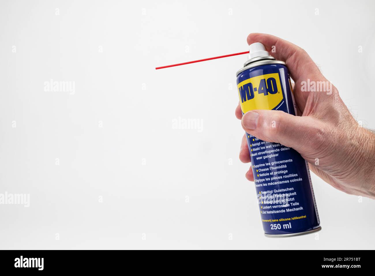 Man mano che regge WD-40 spray universale, fondo bianco, Foto Stock
