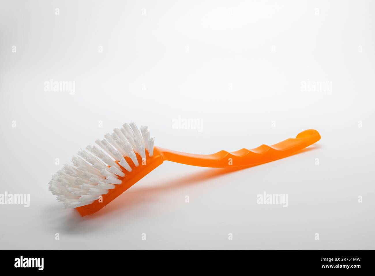 Spazzola per piatti arancione, sfondo bianco, Foto Stock