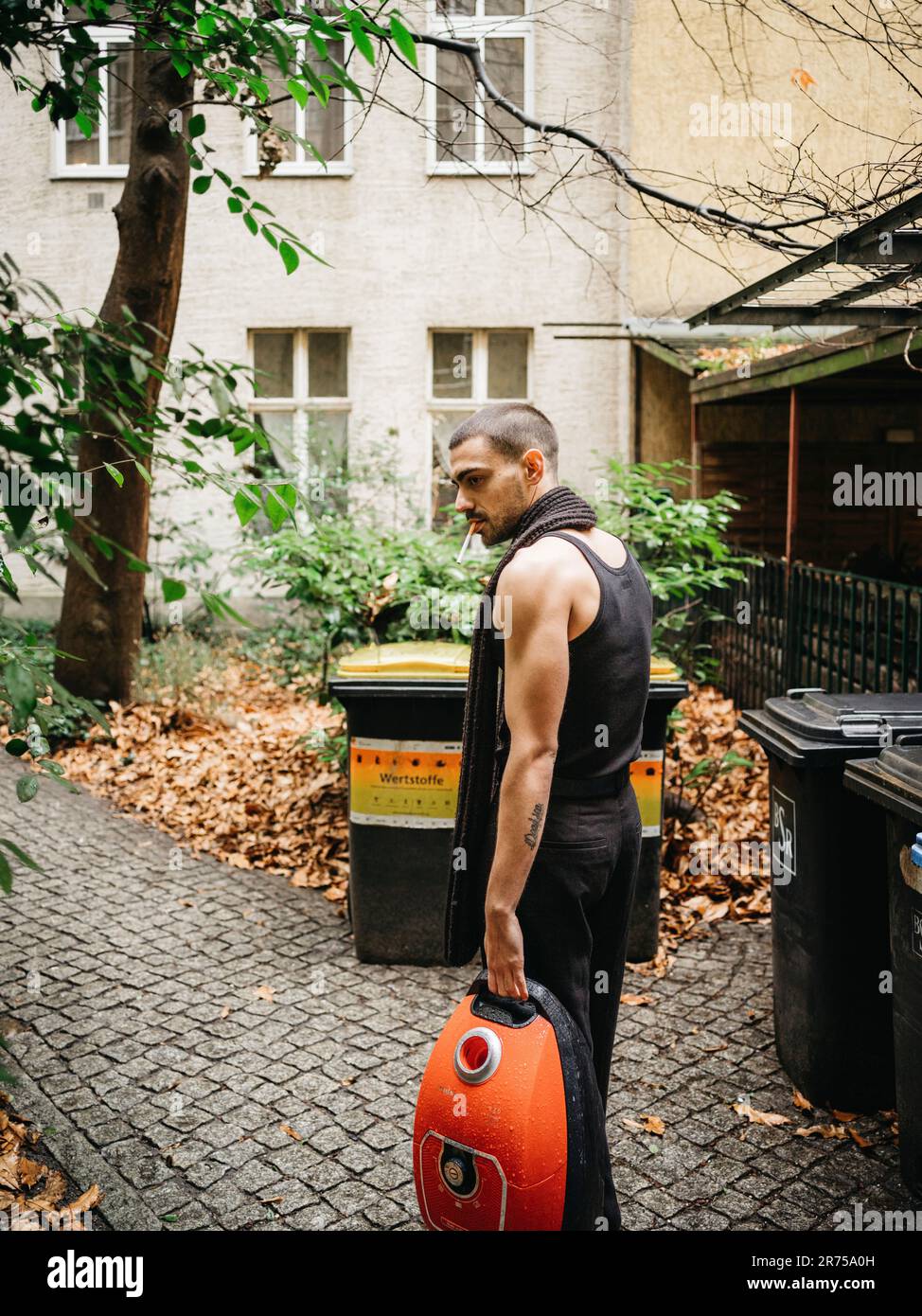 uomo, lateralmente, supporto, aspirapolvere, trasporto, bidoni di immondizia Foto Stock