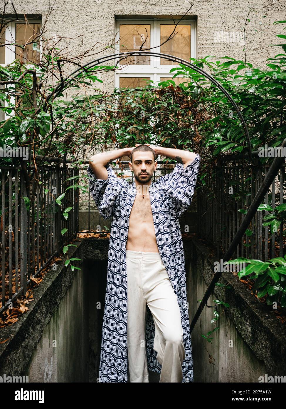 uomo, capelli corti, cappotto, scale di seminterrato, in piedi, guarda la fotocamera, mettiti in posa Foto Stock