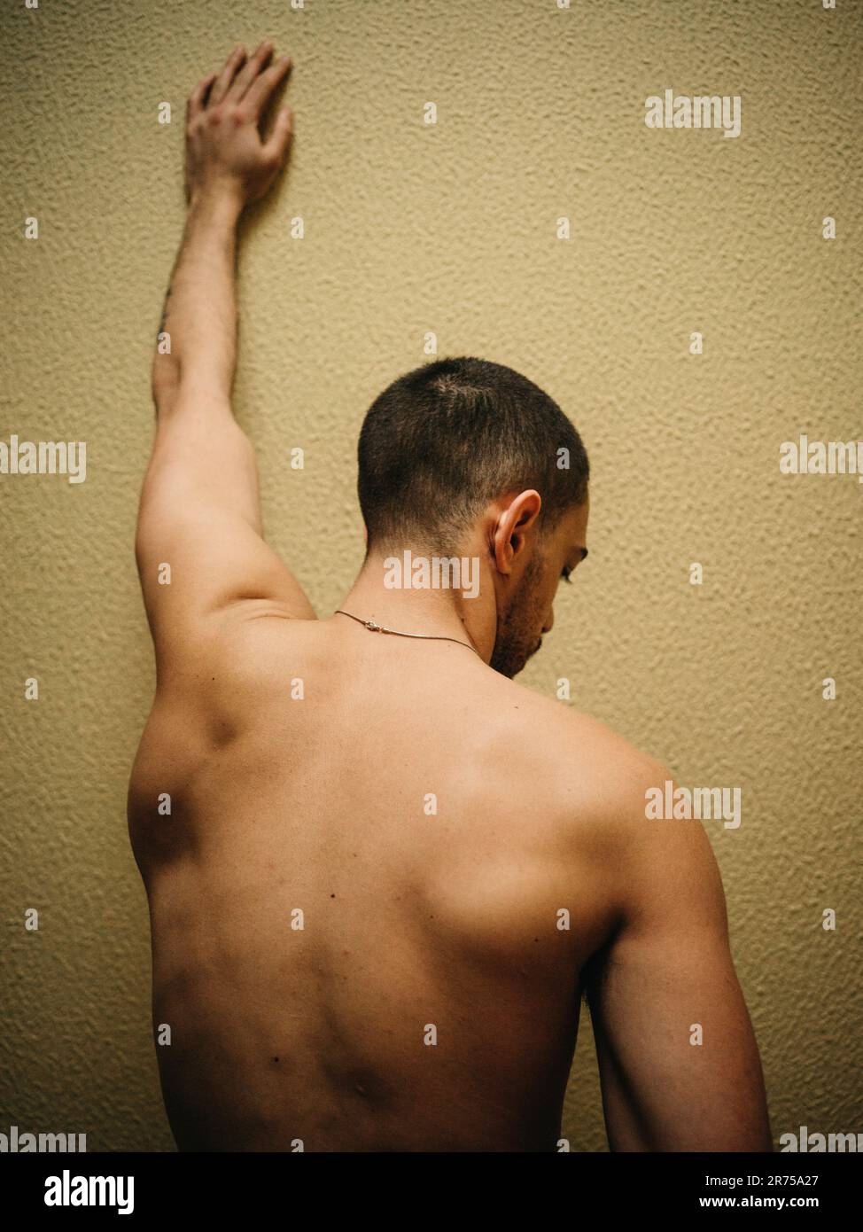 Uomo, parte superiore del corpo libera, braccio, allungare, parete, vista posteriore, Foto Stock