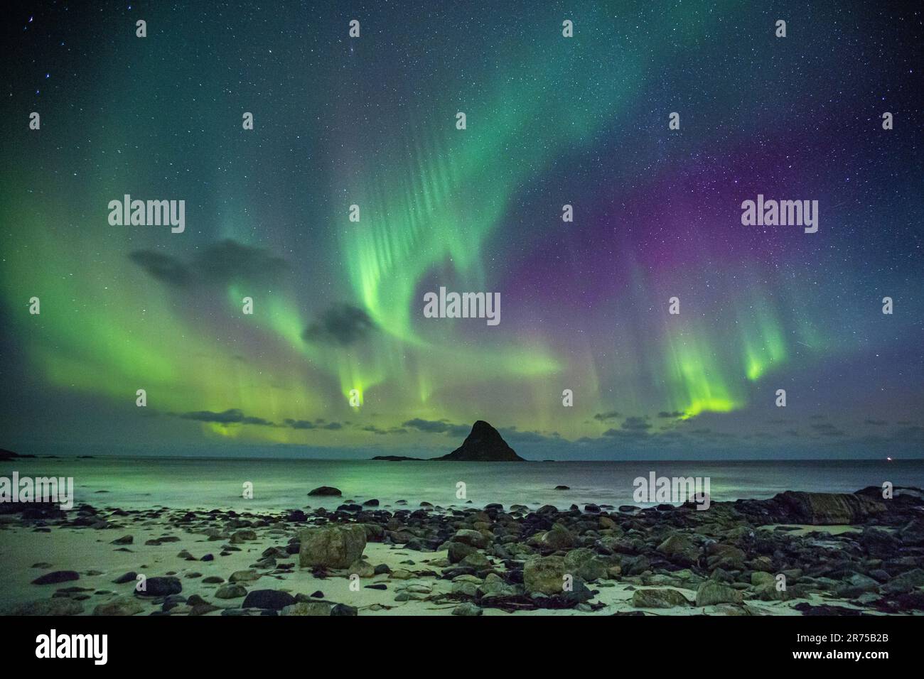aurora borealis multicolore su rocce coniche nel mare, Norvegia Foto Stock