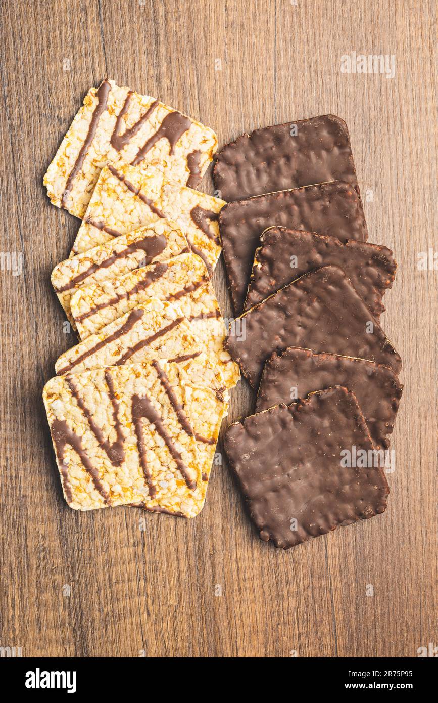 Cracker di mais soffiato cioccolato coperto sul tavolo di legno. Vista dall'alto. Foto Stock