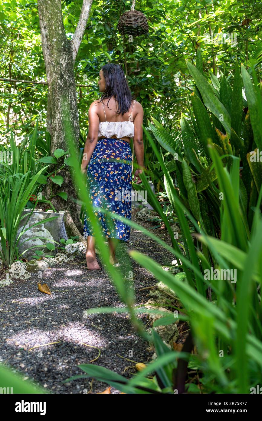 Nord America, Caraibi, grandi Antille, Isola di Hispaniola, Repubblica Dominicana, Costa Nord, Provincia di Puerto Plata, Cabarete, Pretty Latina passeggiate lungo un sentiero nel giardino tropicale del boutique hotel natura Cabana Foto Stock