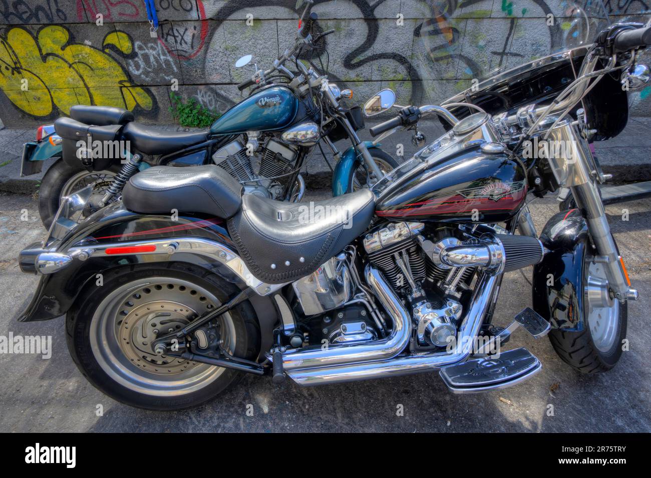 Due scopatori moto parcheggiati di fronte alla parete graffiti catania Easy rider sicilia forcella cromata a V doppia cromata fanny 1400 Harley davidson Foto Stock