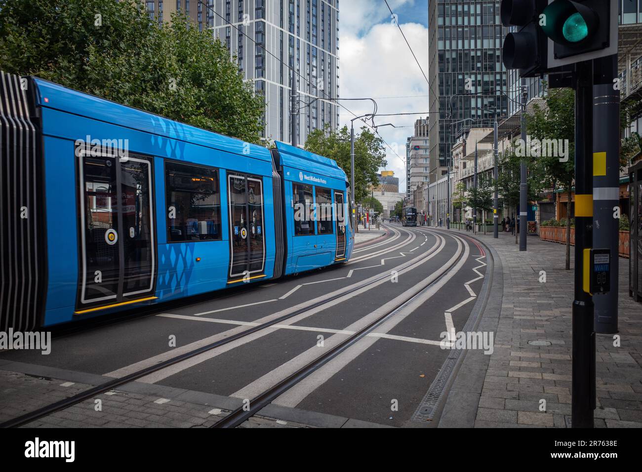 Un tram della metropolitana West Midlands che viaggia lungo Broad Street verso il centro città. La Biblioteca di Birmingham può essere vista in lontananza. Foto Stock