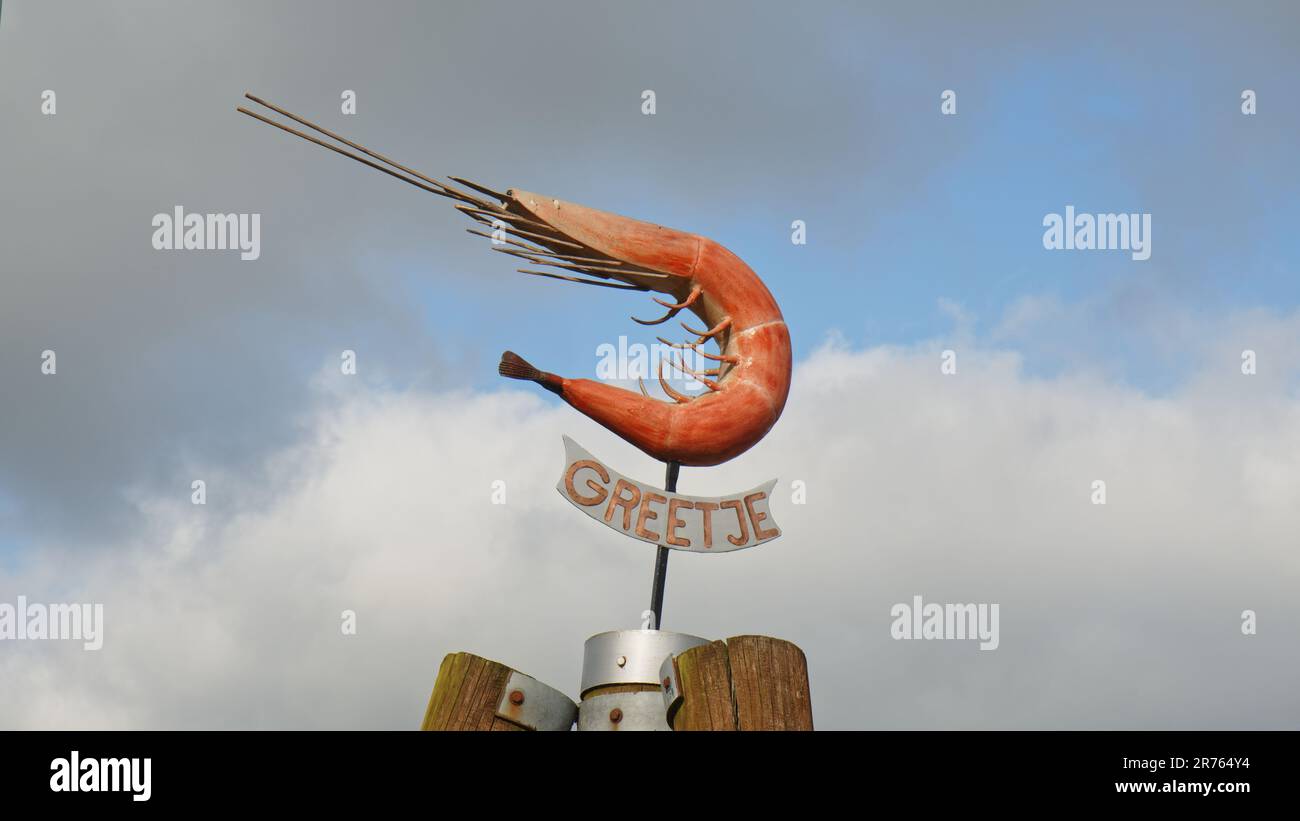 Firma nel porto di Greetsiel ortografia Greetje sotto la scultura di un gambero o granchio in Frisia orientale. Foto Stock