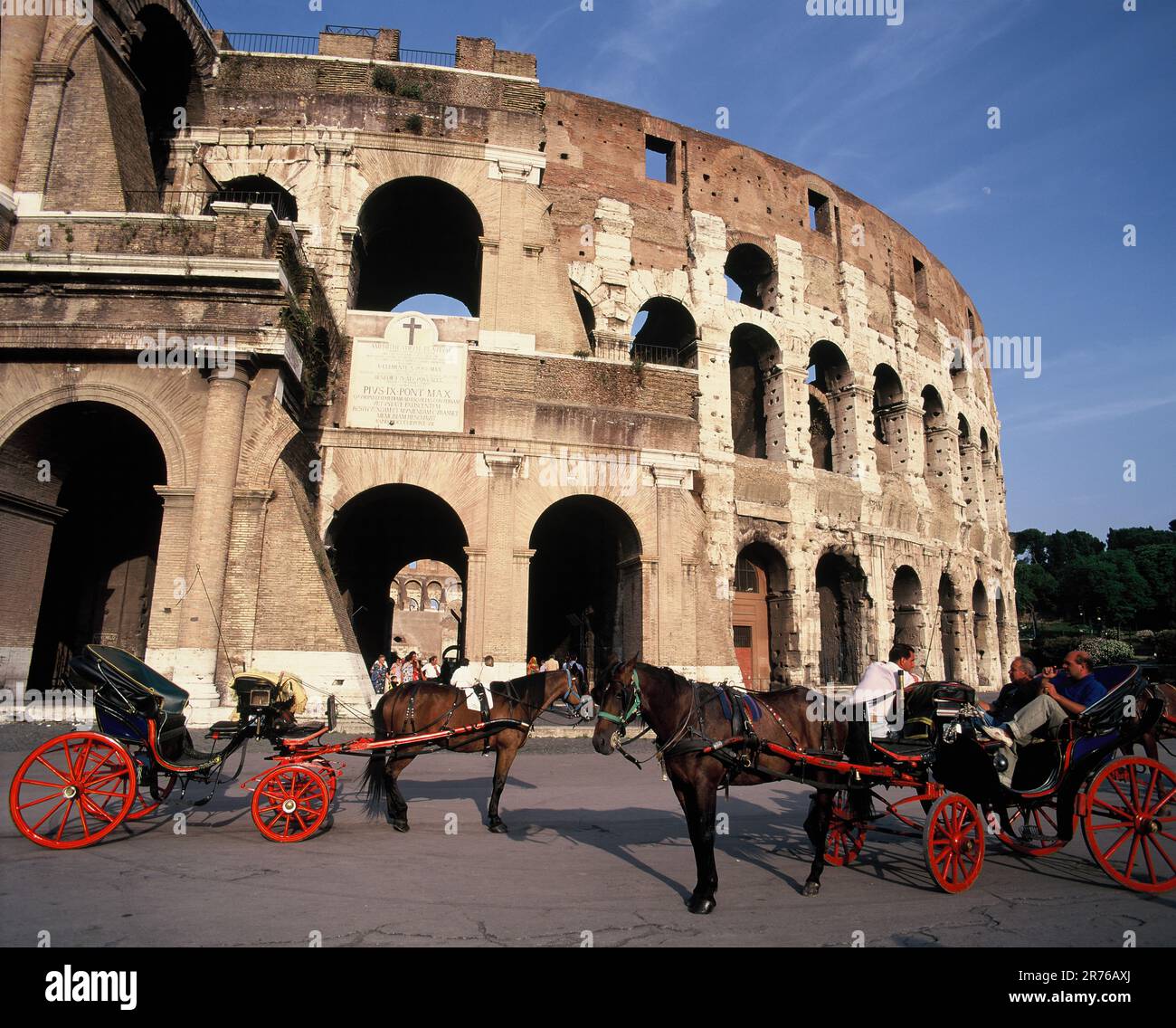 Italia. Roma. Il Colosseo con carrozze turistiche trainate da cavalli. Foto Stock