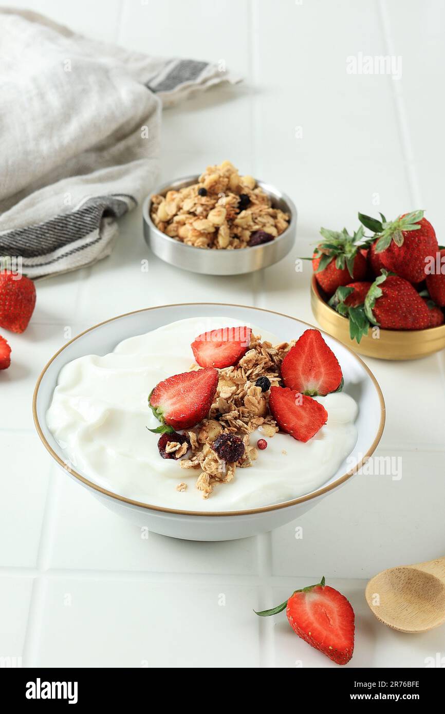 Yogurt con muesli e fragola. Yogurt greco bianco semplice con berries freschi e muesli. Cibo sano, colazione. Foto Stock