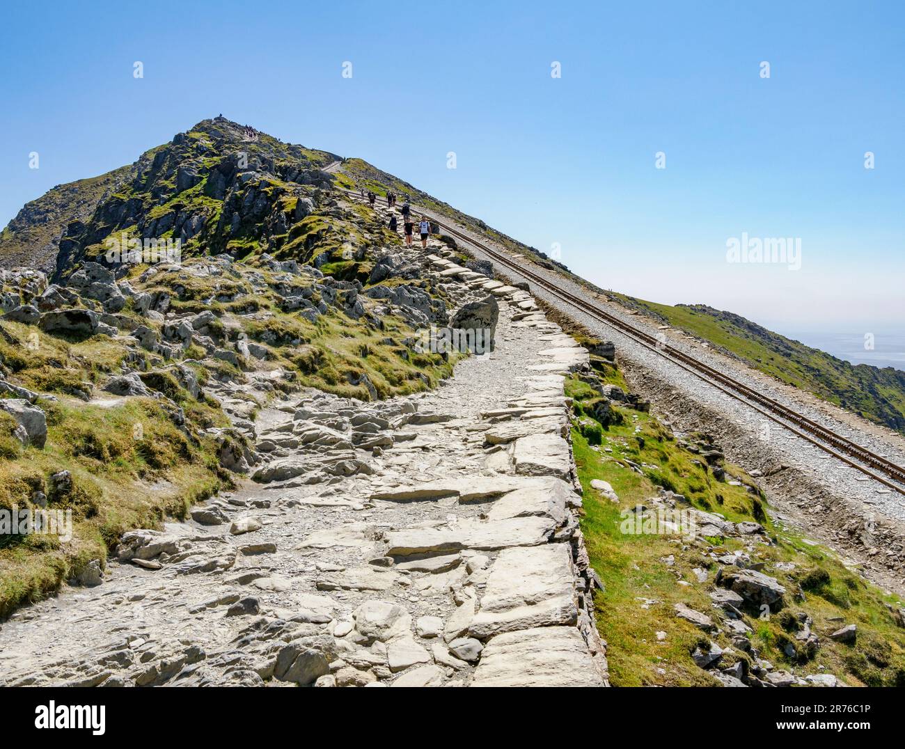 Pista asfaltata e Snowdon Mountain Railway che condividono l'ultima salita della cresta fino alla cima dell'Yr Wyddfa nel Parco Nazionale di Eryri, Galles del Nord, Regno Unito Foto Stock