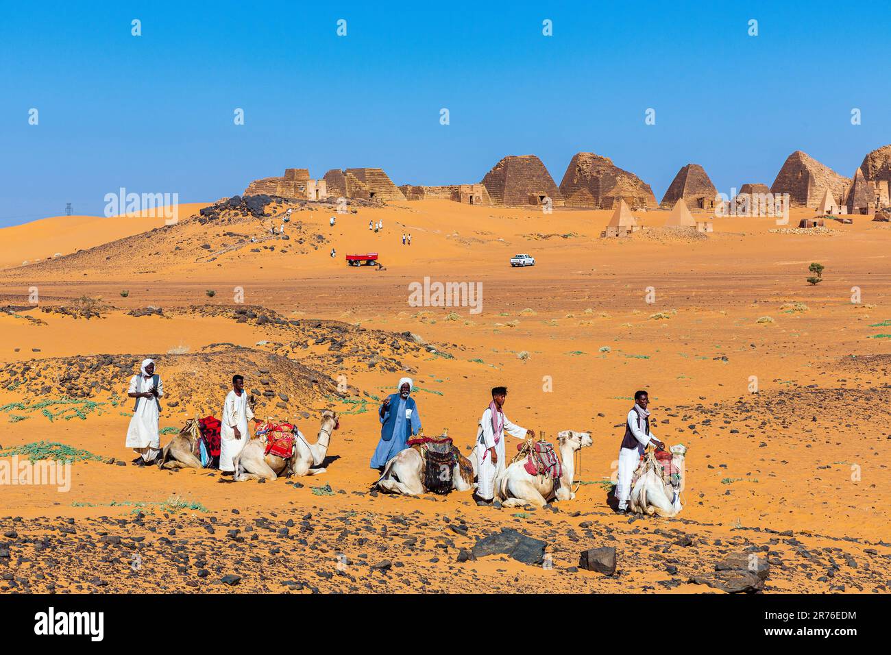 gli arabi vestiti tradizionalmente con i loro cammelli aspettano i turisti alle piramidi nubiane a meroe in sudan Foto Stock