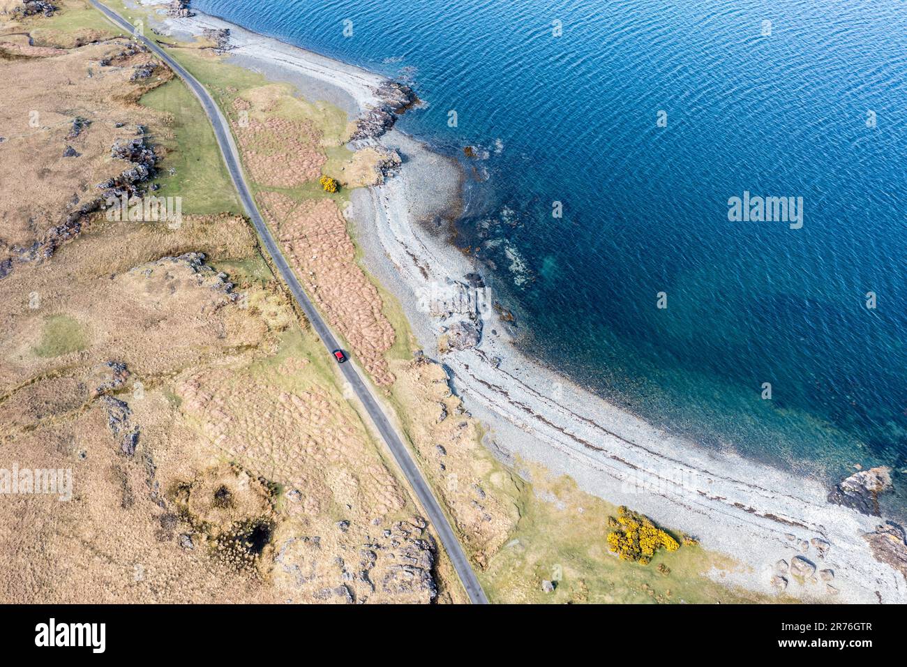 Vista aerea sulla costa di Loch na Keal, strada costiera e auto solitaria rossa su strada a binario singolo, Isola di Mull, Scozia, Regno Unito Foto Stock