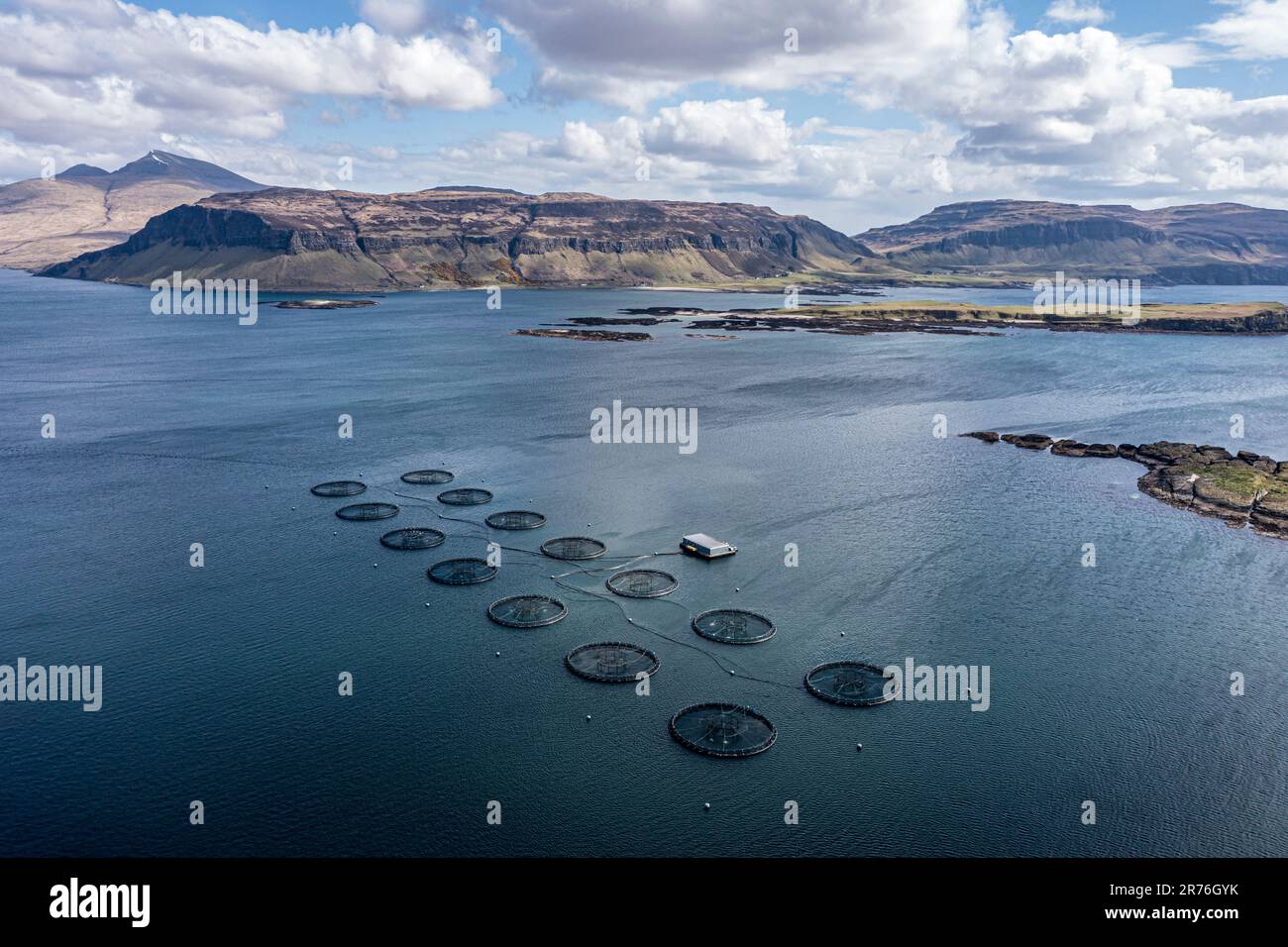 Gabbie galleggianti di un allevamento di salmone, mare tra l'isola di Ulva e l'isola di Mull, mt. Ben More (Mull) sul retro, vista aerea, Scozia, Regno Unito Foto Stock