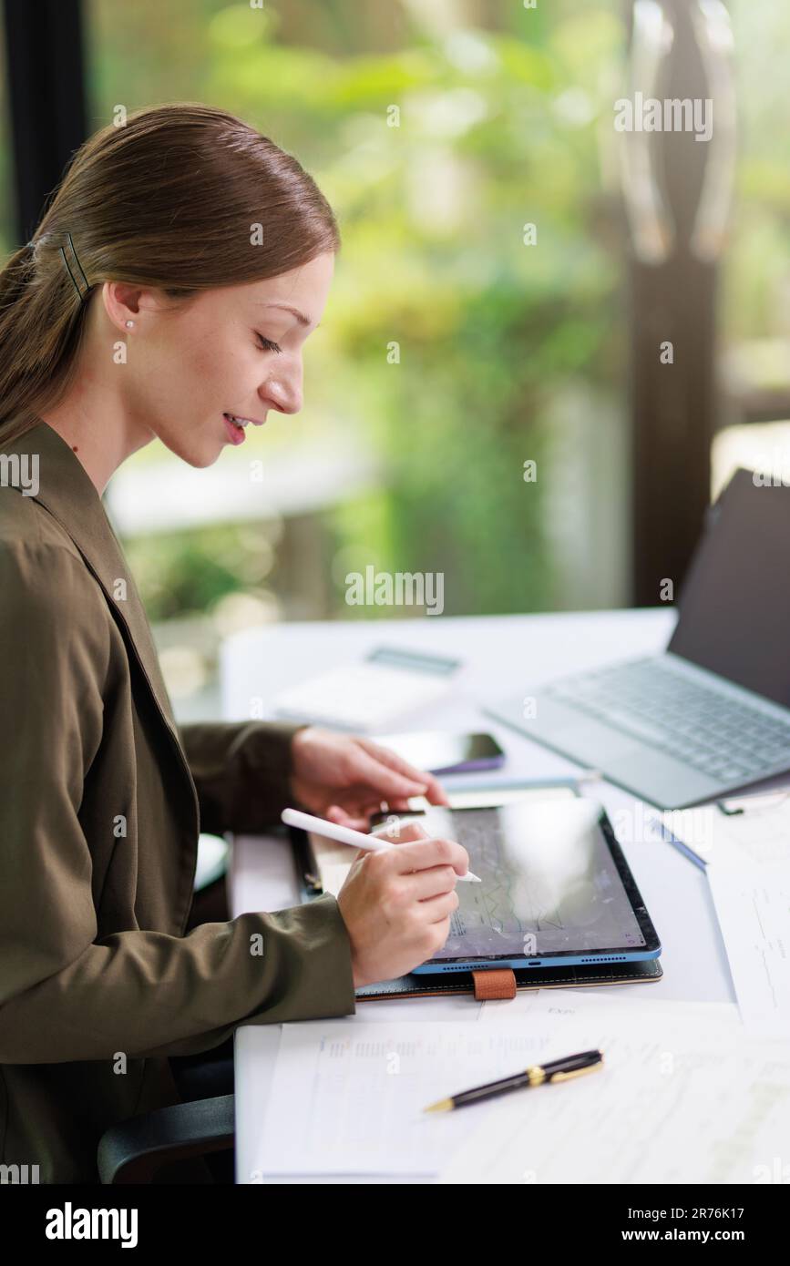 Concetto di business Office donna che lavora, Businesswoman sorriso mentre lavorando sul suo piano di invesment con l'analisi di documenti e di business investment gr Foto Stock