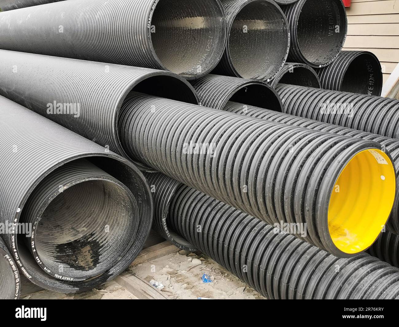 Un mazzo di tubi corrugati in HDPE a doppia parete sul terreno. Foto Stock