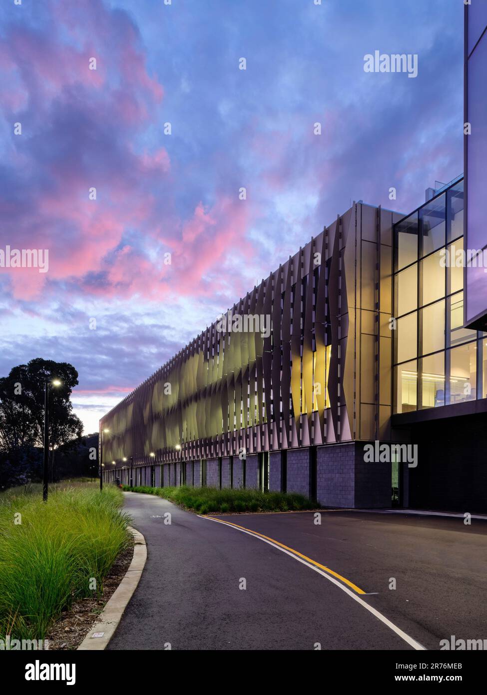 Elevazione sud con lame di metallo e motivo a onde gravitazionali sulla facciata. Preso dalla pista ciclabile. Australian National University Research School of Foto Stock
