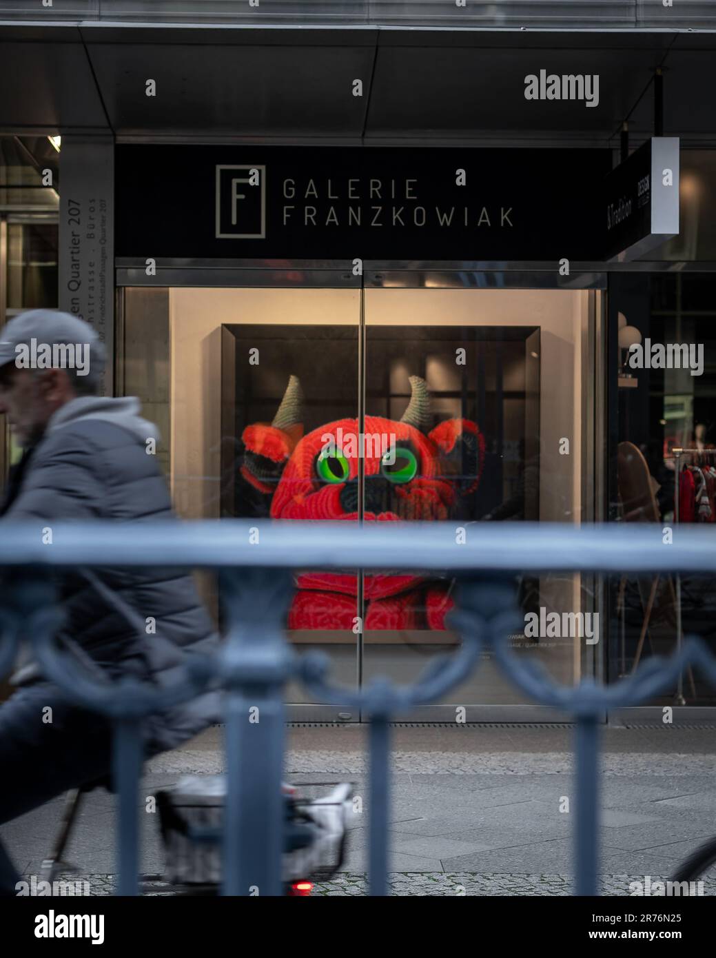 una creatura mitica giocattolo imbottita con corna, capelli rossi e soffici e occhi verdi dipinti sulla porta d'ingresso di un centro commerciale. Foto Stock