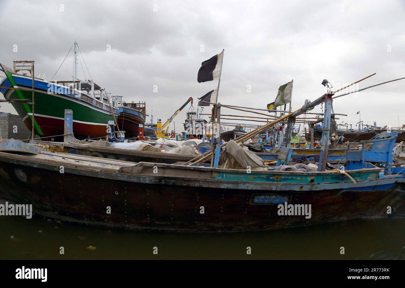 Karachi, Pakistan, 13 giugno 2023. Un gran numero di barche viste ormeggiate a Ibrahim Hyderi Fish Harbor a causa del ciclone tropicale e osservare le condizioni del mare accidentato come attività costiere sono state vietate dopo un avvertimento emesso dal dipartimento di meteorologia in merito ad una tempesta tropicale estremamente grave ciclone chiamato Biparjoy, a Karachi il Martedì, 13 giugno 2023. Il Dipartimento metrologico pakistano (PMD) ha annunciato martedì che il ciclone Biparjoy si trovava a 470 chilometri a sud di Karachi, e a 460 km da Thatta mentre si spostava più a nord-ovest durante le ultime 12 ore. Foto Stock