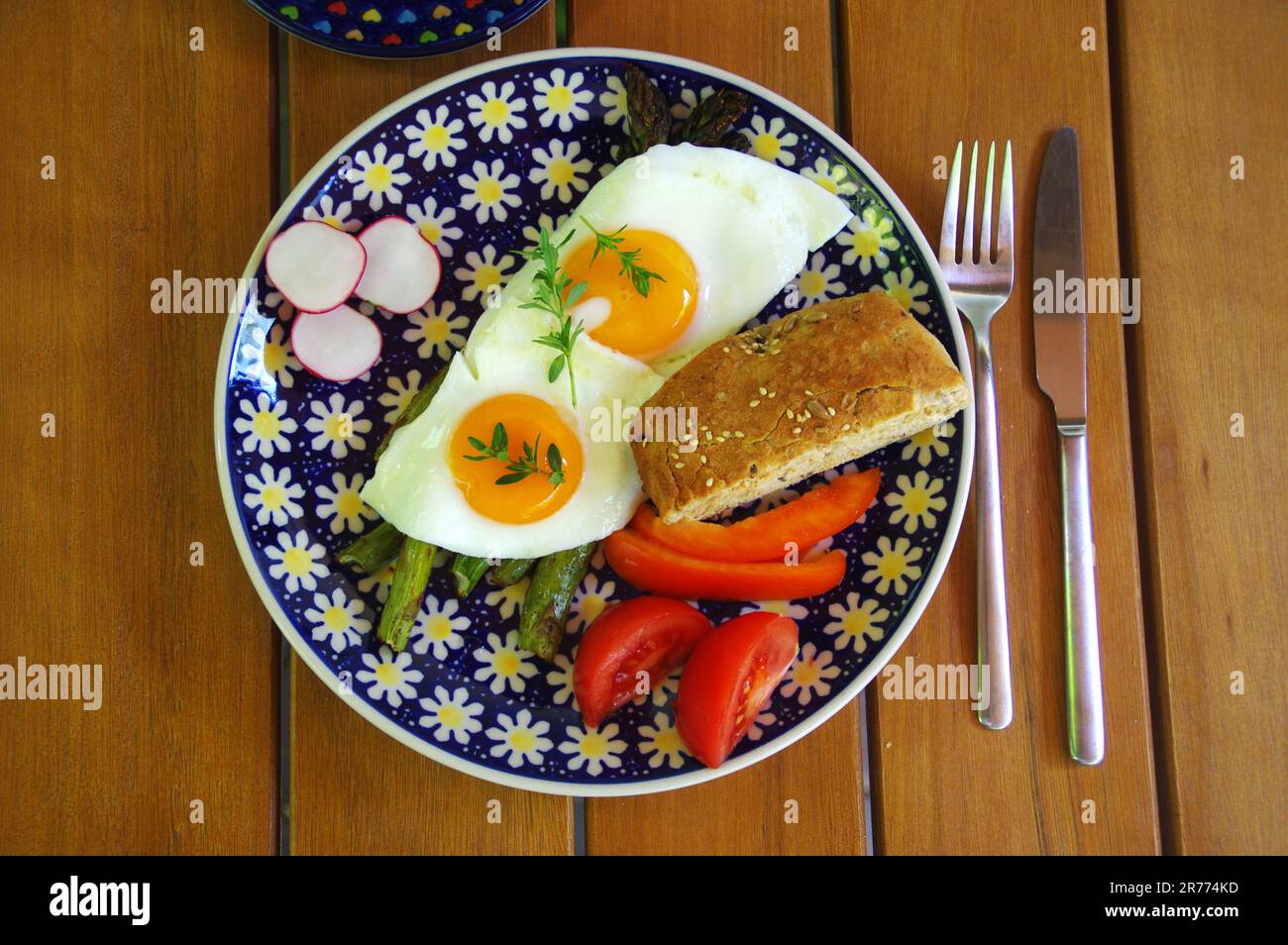 Asparagi verdi alla griglia con uova fritte, pane e erba cipollina. Colazione fresca su piatto. Foto Stock