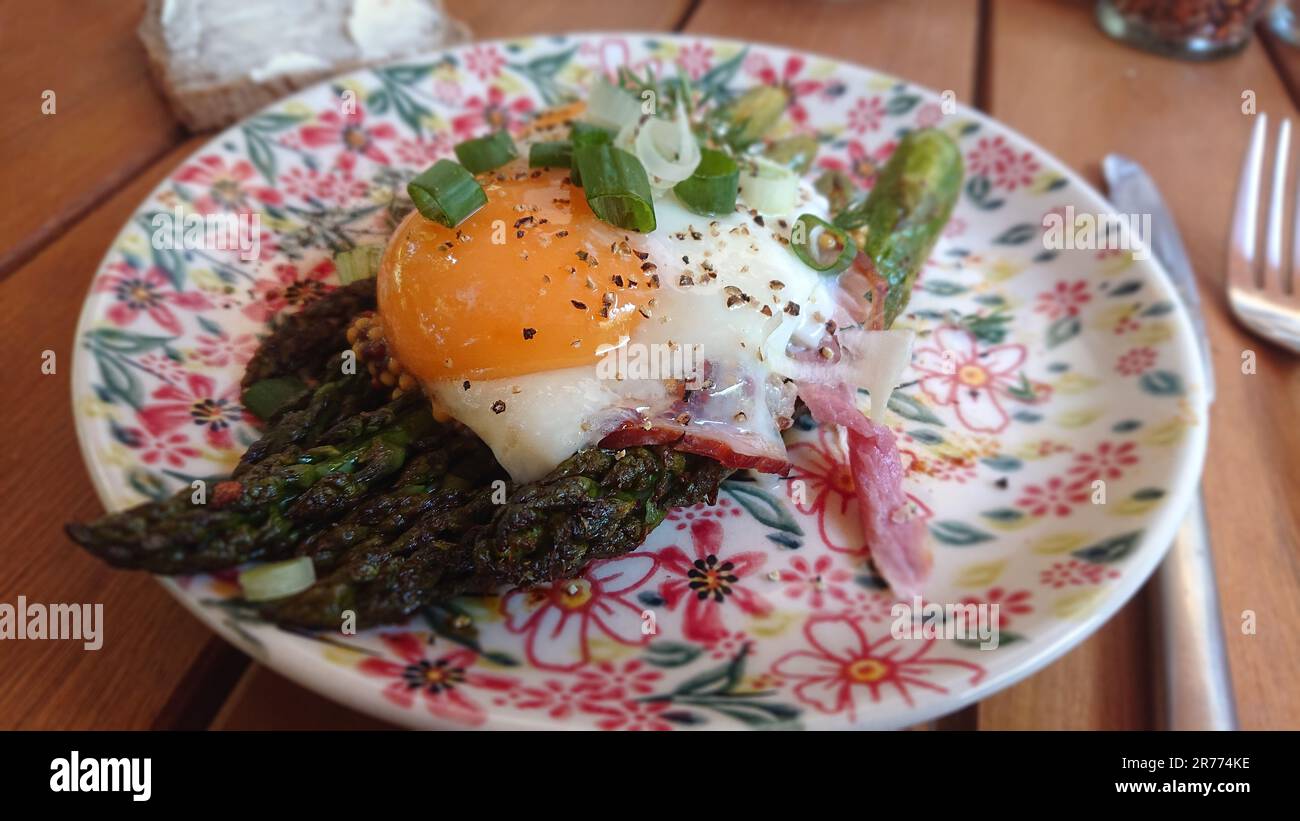 Asparagi verdi alla griglia con uova fritte e erba cipollina. Colazione fresca su piatto. Foto Stock