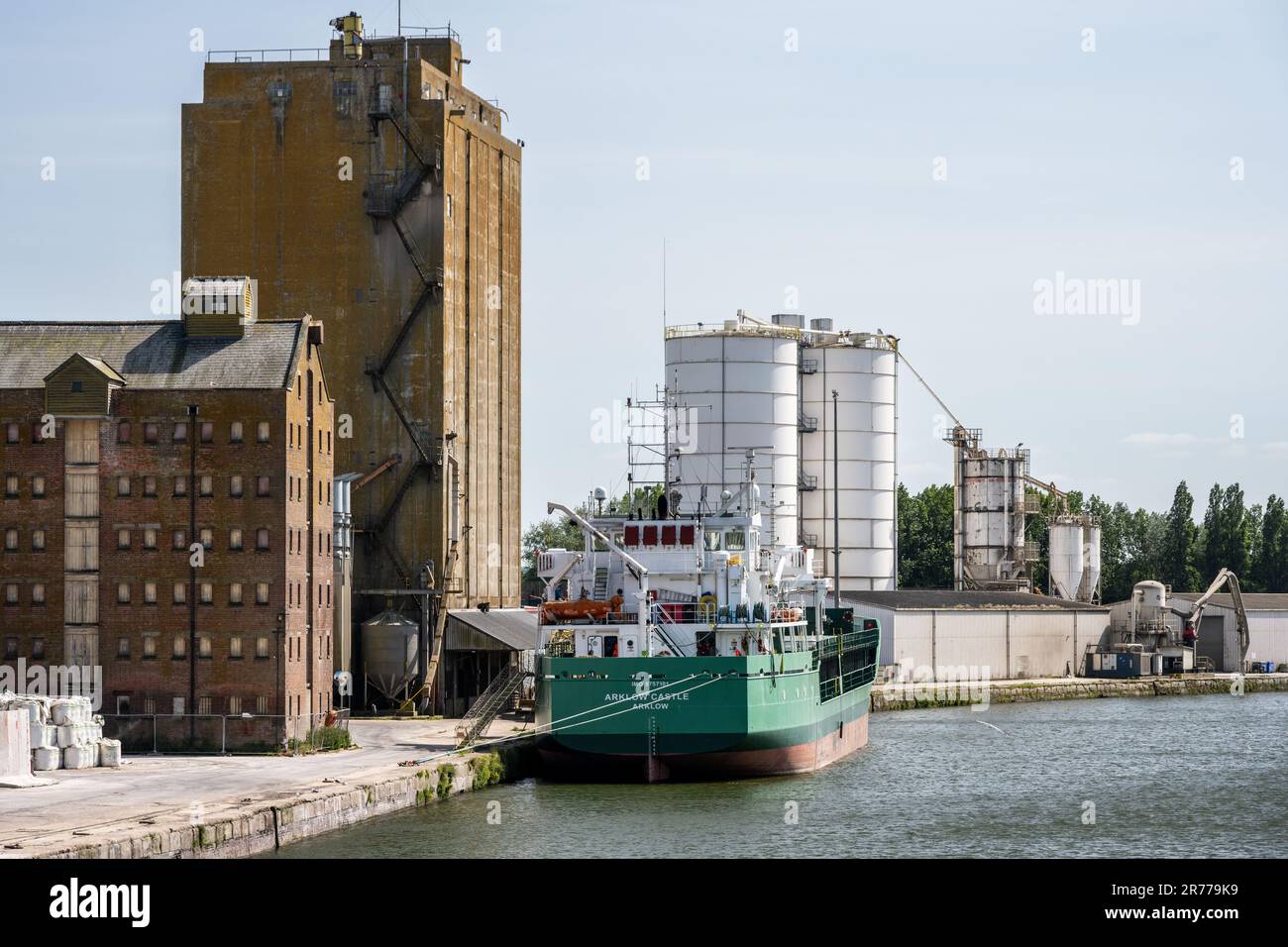 Una nave da carico è ormeggiata accanto a silos di grano e magazzini a Sharpness Docks in Gloucestershire, Inghilterra. Foto Stock