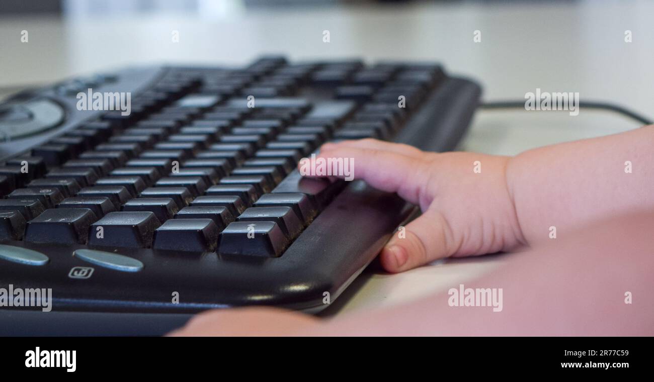 Mano di un bambino con la tastiera del computer Foto Stock