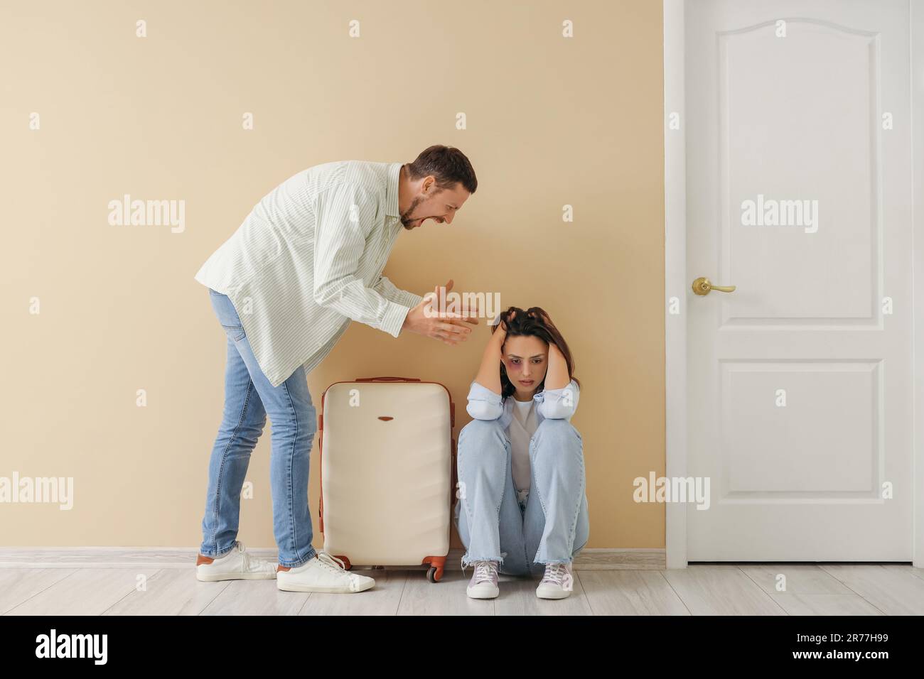 Giovane donna livisa con valigia e suo marito arrabbiato vicino