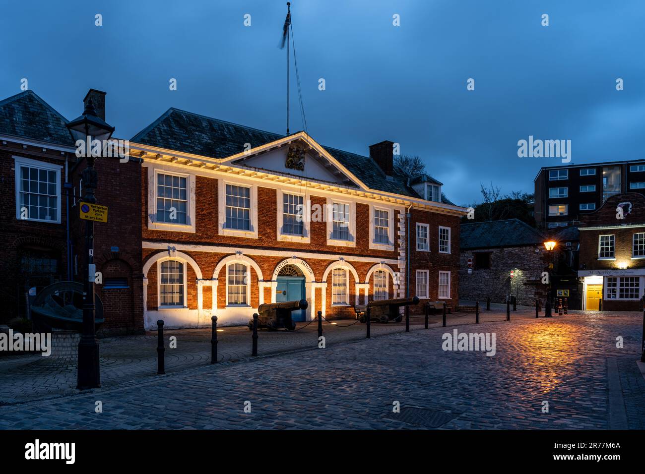 La storica Custom House di Exeter è illuminata di notte sul molo. Foto Stock