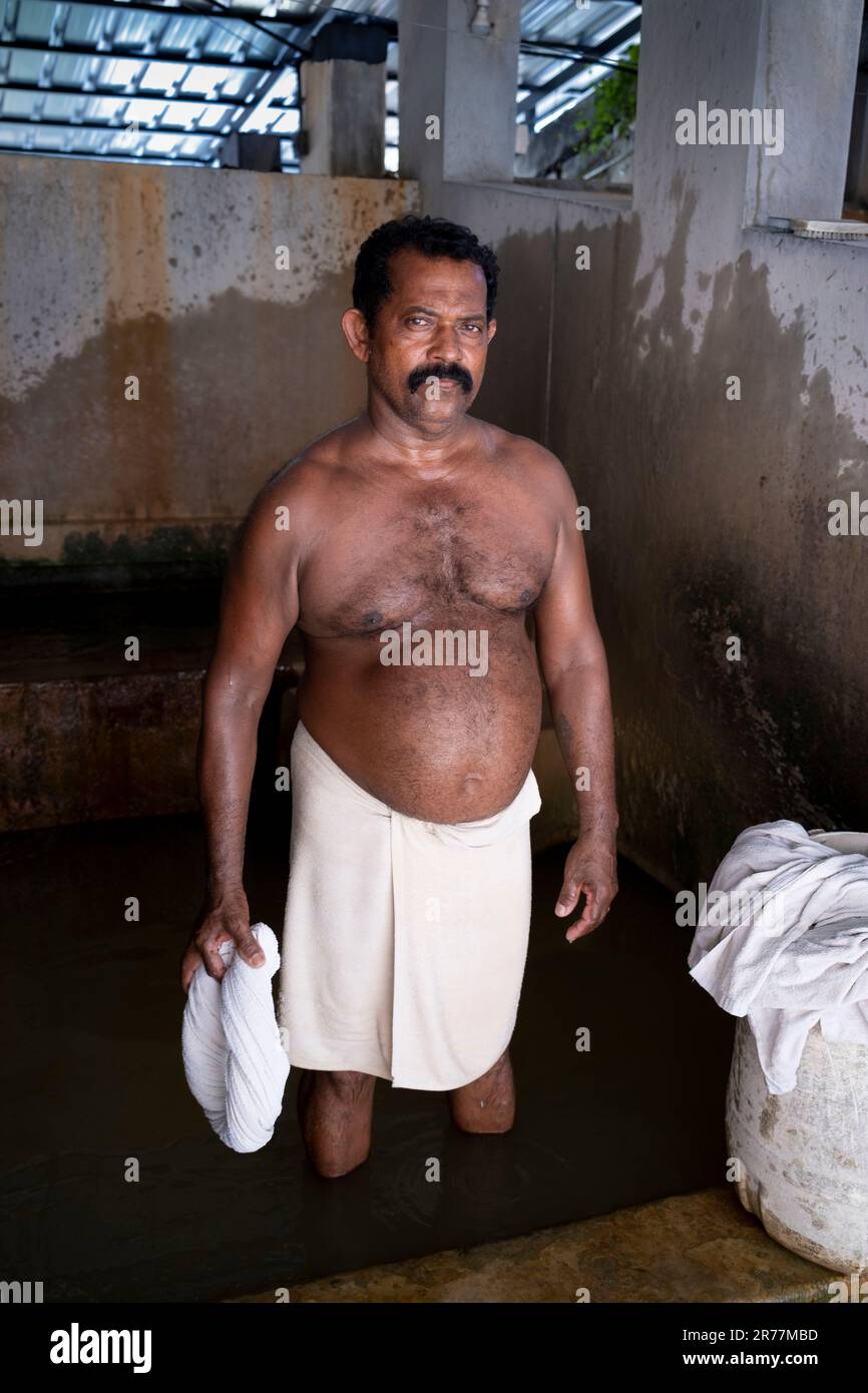 Uomo che lava i vestiti a mano nella lavanderia tradizionale, nel quartiere coloniale di Fort Kochi, Kochi, Kerala, India, Asia. Foto Stock