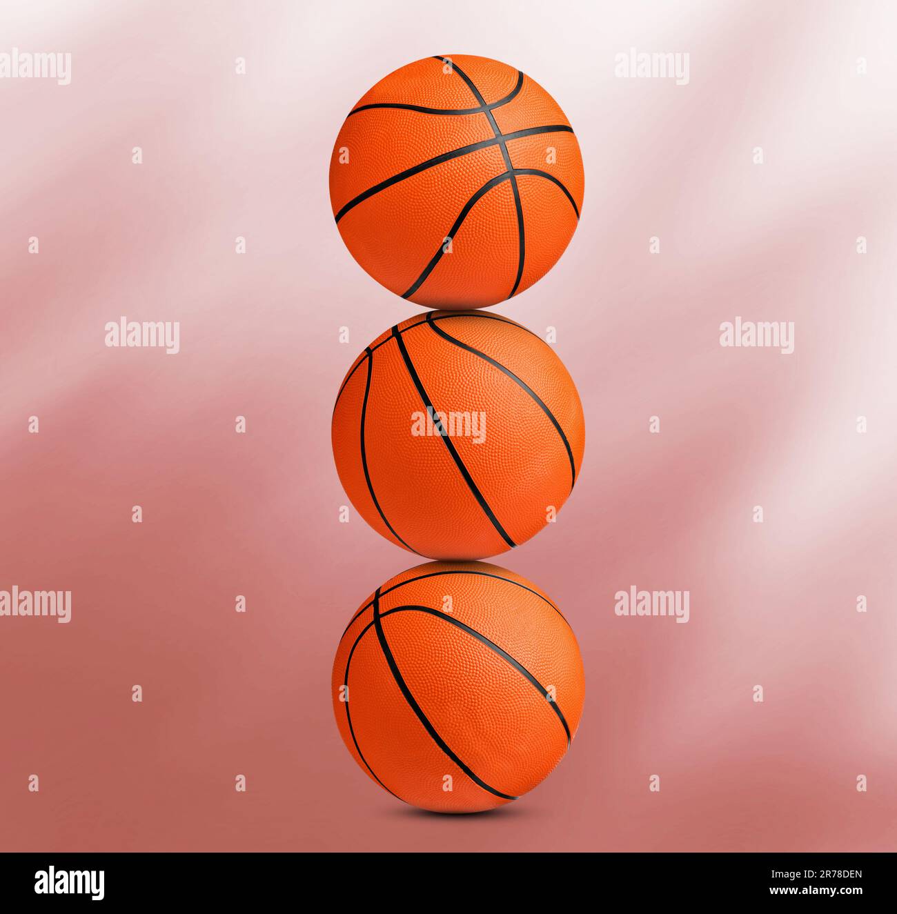 Pila di palline da basket su sfondo corallo Foto Stock