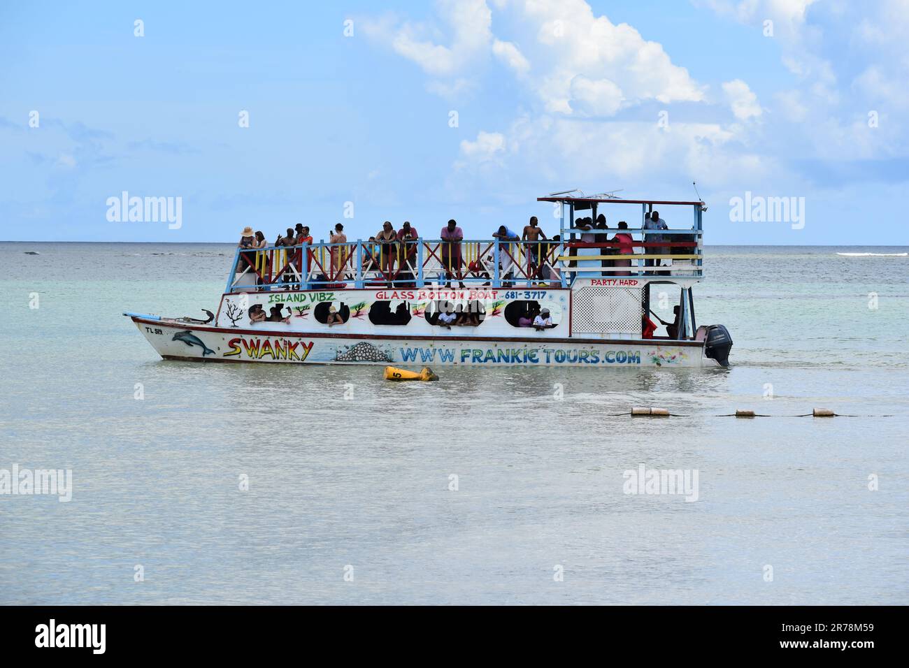 Barche con fondo in vetro a Pigeon Point che trasportano turisti in tour per vedere la barriera corallina di Buccoo, la piscina di Nylon e la Terra di No Man a Tobago. Foto Stock